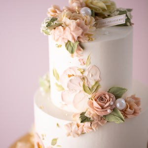 
                  
                    Load image into Gallery viewer, A close up on the hand piped and palette knife buttercream flowers. There are edible sugar pearls in variou sizes scattered around the flowers, looking like dew drops. There is also gold leaf that has been carefully applied around the cake for a pop of glamour.
                  
                