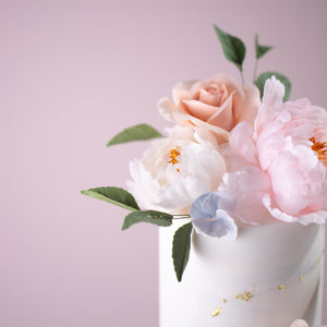 
                  
                    Load image into Gallery viewer, A close up on the other flowers on top of the cake. There is a smaller white sugar peony next to the larger light pink one, and behind there is a peach coloured sugar rose. There are green sugar leaves around the flowers to make them look even more real.
                  
                