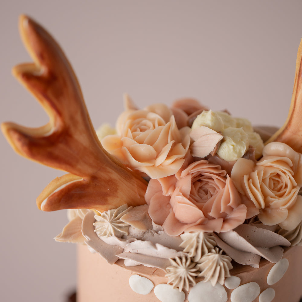 
                  
                    Load image into Gallery viewer, A close up on the 3D hand piped buttercream flowers, and the cookie antler.
                  
                