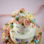 A close up on the hand piped buttercream flowers in pastel colours. They look incredibly realistic.