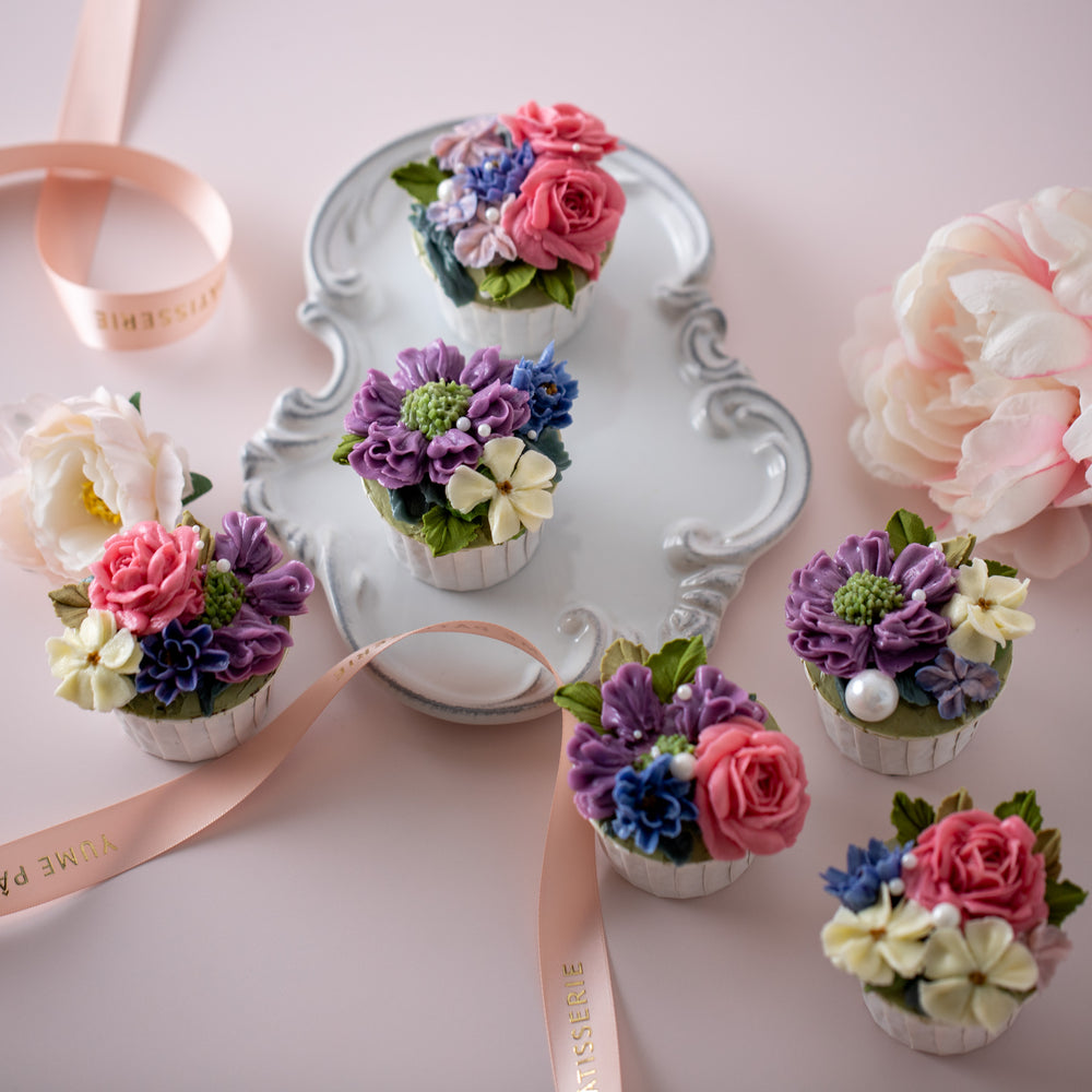 
                  
                    Load image into Gallery viewer, 6 cupcakes with assorted hand piped buttercream flowers in vibrant pink, purple, blue and ivory. There are sugar pearls lightly sprinkled on top. The flowers look incredibly realistic and beautiful.
                  
                