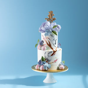 
                  
                    Load image into Gallery viewer, A two tier Longevity theme cake. There are two hand painted cranes on the cake, along with some hand painted branches and floral details. On the top of the cake, there are two large sugar peonies, and all around the cake there are small sugar hydrangeas. There are five small fondant peaches around the cake
                  
                