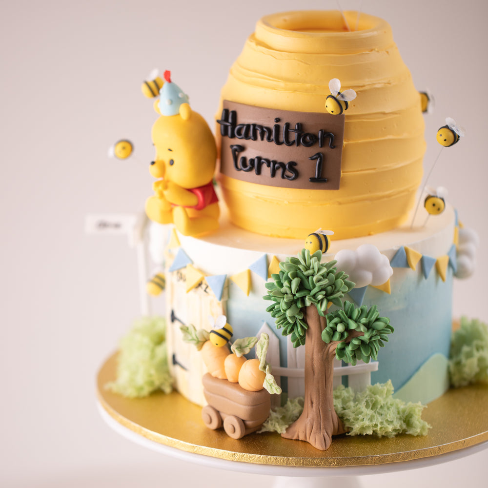 A close up on the side of the Winnie the Pooh Cake. There are many hand crafted fondant details on the cake that look extremely cute.