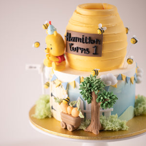 
                  
                    Load image into Gallery viewer, A close up on the side of the Winnie the Pooh Cake. There are many hand crafted fondant details on the cake that look extremely cute.
                  
                