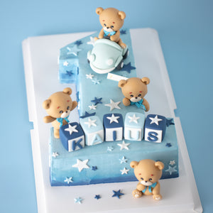 
                  
                    Load image into Gallery viewer, A large cake carved into the number &amp;quot;one&amp;quot; with an ombre blue buttercream base. There are four fondant bears on the cake, one of which is driving a light blue car. There are white and blue fondant stars in various shapes all around the cake. At the base of the &amp;quot;one&amp;quot;, there are 3D fondant alphabet blocks that spell the name &amp;quot;Kaius&amp;quot;.
                  
                