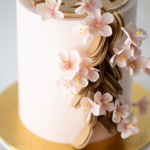 
                  
                    Load image into Gallery viewer, A close up of the gold scallops and light pink edible sugar plum blossoms.
                  
                