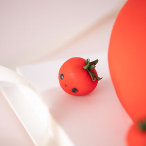 
                  
                    Load image into Gallery viewer, A close up on one of the other fondant cherry tomatoes on the cake board. It has a simple, happy expression, and looks like the emoticon :&amp;gt;
                  
                